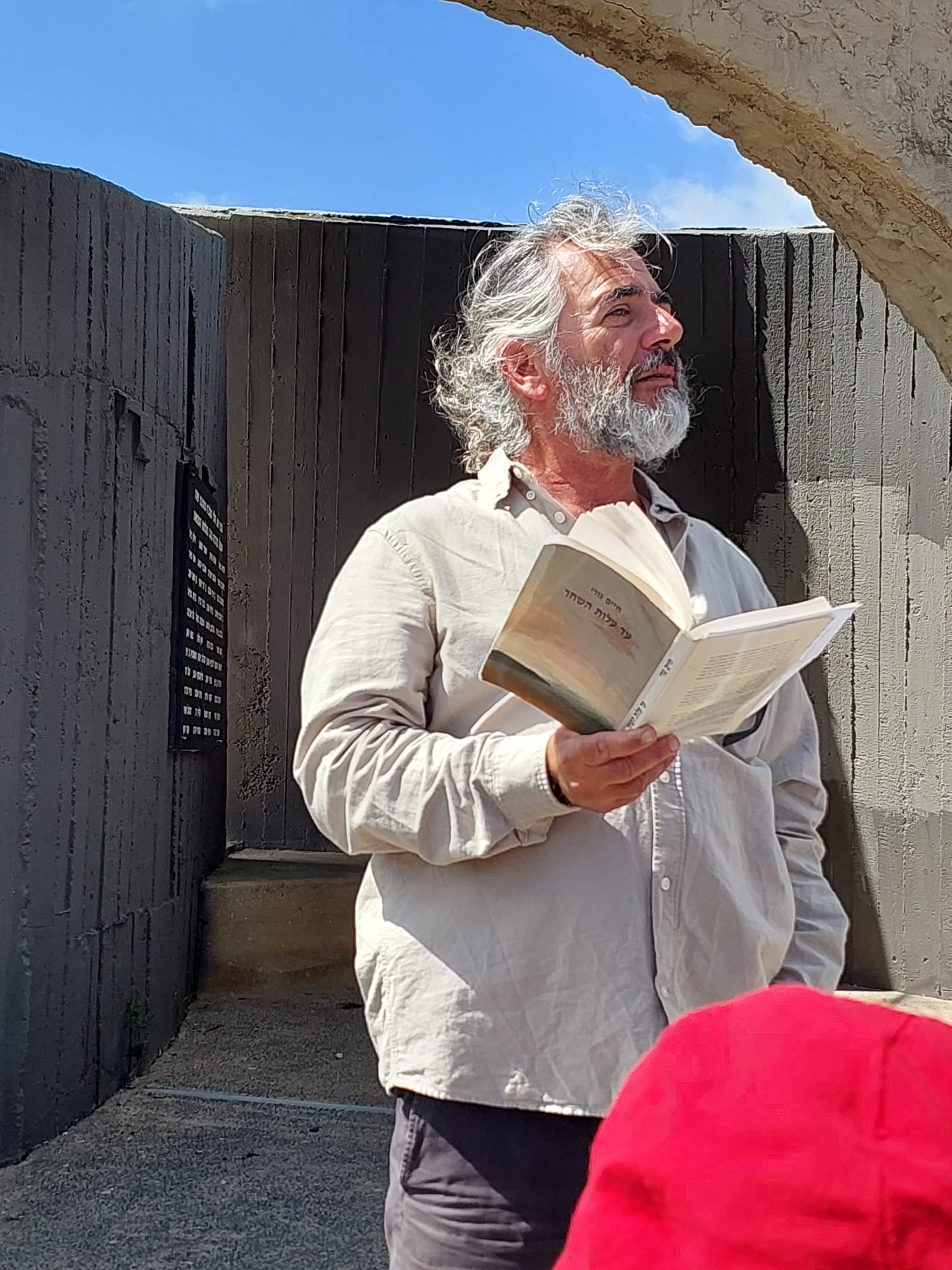 Baruch Shmulewitz reading from a book on a walking tour