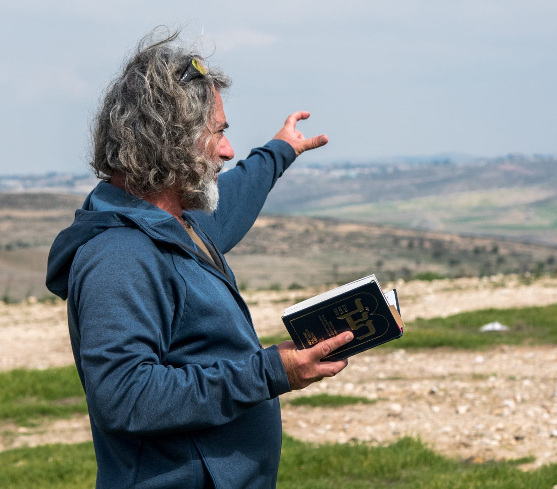 Baruch Shmulewitz pointing across the Galilee landscape